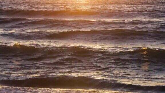 暴风雨的大海日落自然戏剧性的海景日落或日出阳光透过金色的波浪海洋和海洋慢动作4k