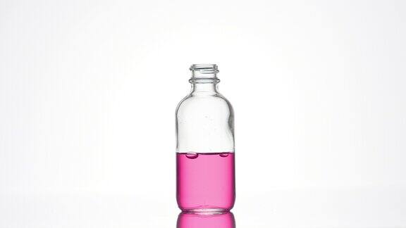 视黄醇正用粉红色液体倒进药瓶