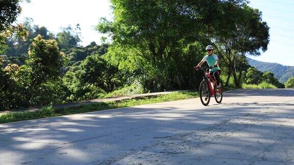 在一个阳光明媚的日子里一个女人在山坡上骑自行车