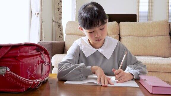 一个小学生在客厅做作业