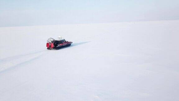 在冬季风景鸟瞰图中救援气垫船行驶在雪白的地面上