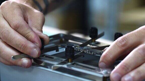 修理工用手夹住虎钳内的小芯片组来修复和焊接元件