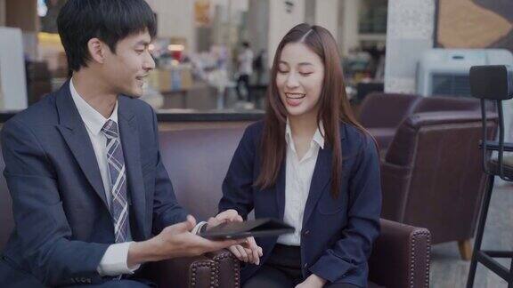 年轻的商人在商务会议上用笔记本电脑与女顾客握手
