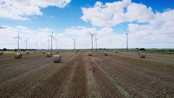 一段令人惊叹的航拍视频捕捉到了林肯郡农民新收获的田地里风力涡轮机的优美舞蹈金色的干草捆增添了魅力
