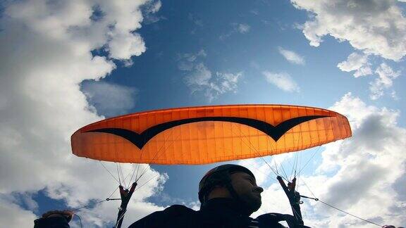 空中滑翔运动一个男性滑翔伞正随着飞行器向天空移动