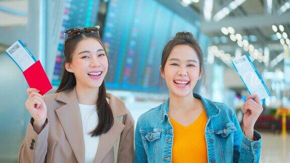亚裔女性站在机场候机厅的登机口迷人美丽的女游客旅客感到快乐和兴奋去国外旅游的飞机假期旅行