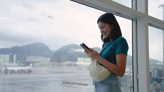 玩手机通讯在候机楼内等候登机的女子旅行