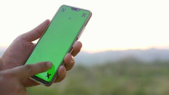 在大自然中使用和清扫绿色屏幕智能手机色度键