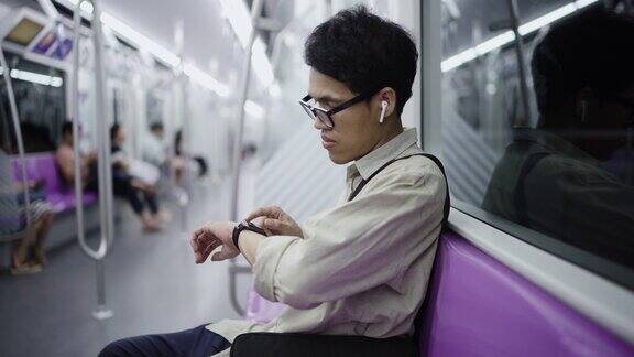 亚洲男人用他的智能手表他正在查看电子邮件、短信或使用移动应用程序