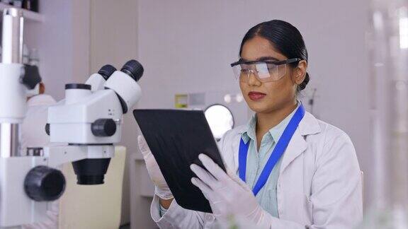 药片实验室研究和科学妇女显微镜数据分析和医学试验的生物技术专业的科学家与快乐的数字疫苗或医疗保健分析在实验室