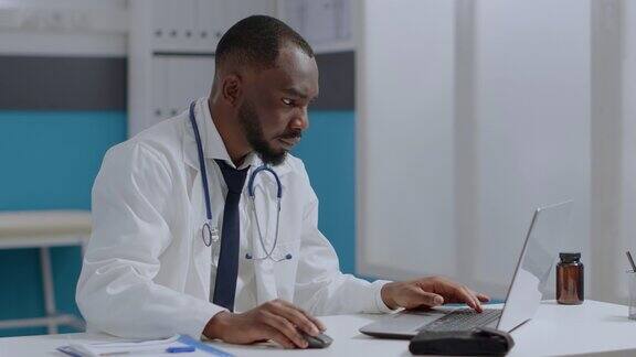 非裔美国治疗师医生坐在桌子上打字的疾病专家在笔记本电脑