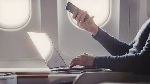一个在商务飞机上使用笔记本电脑的人