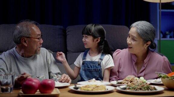 亚洲人幸福的家庭在餐桌上吃午餐日本人在一起微笑小孩子女儿喜欢吃爷爷奶奶的食物幸福时光人们的生活方式观念