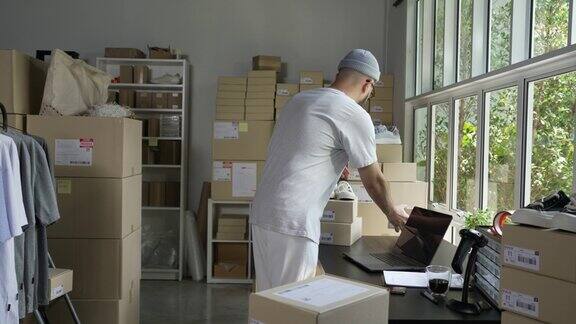 亚洲人企业主工作包装订单运输到客户男企业家包装箱供仓库配送快速运动