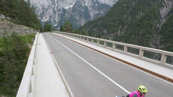 空中夫妇骑自行车穿过山上一座漂亮的桥