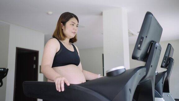 孕妇在健身房里在跑步机上行走锻炼身体和心脏健康