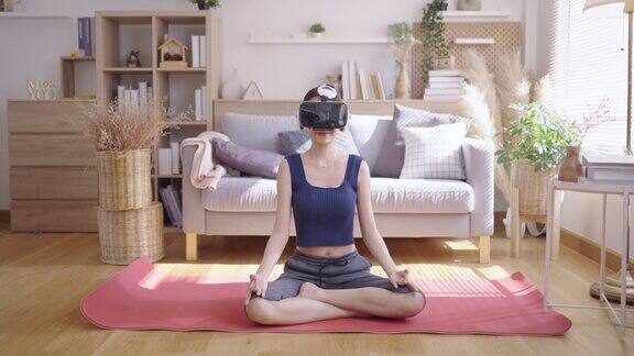 年轻的亚洲女性戴着VR眼镜在家做瑜伽