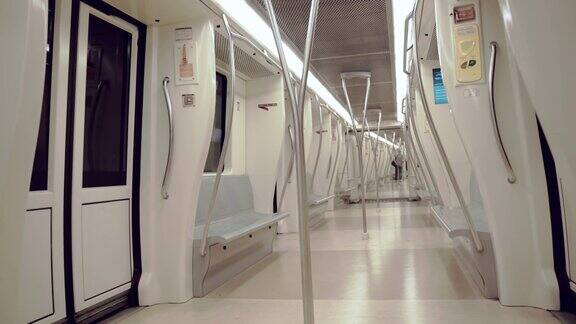一个现代的白色长地铁列车每天在高速地下行驶的内部视图半空的地铁正驶近罗马城的车站人们正站起来准备下地铁