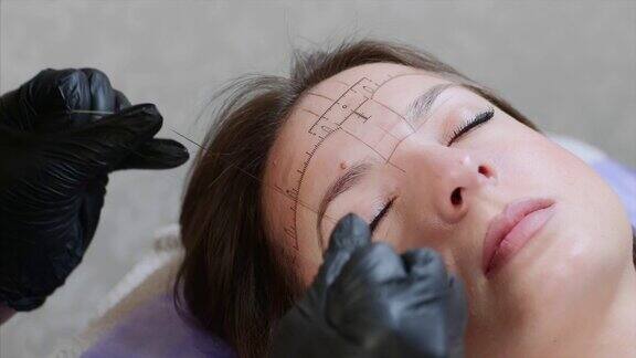 一位专家正在用一根线标记眉毛的最顶端这是特写