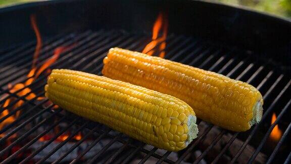 在烤架上烤新鲜的玉米棒