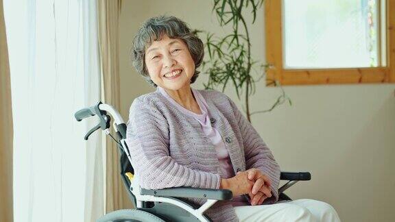坐在轮椅上的老妇人在窗边笑