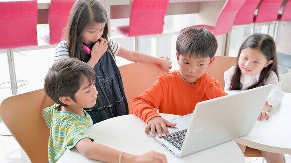 亚洲可爱的孩子学生在教室里一起使用笔记本电脑