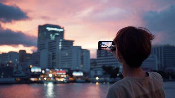 一名亚洲年轻人用智能手机拍照