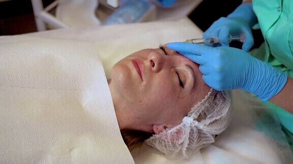 美容师为女性客户注射神经毒素年轻化程序美容疗法护肤概念