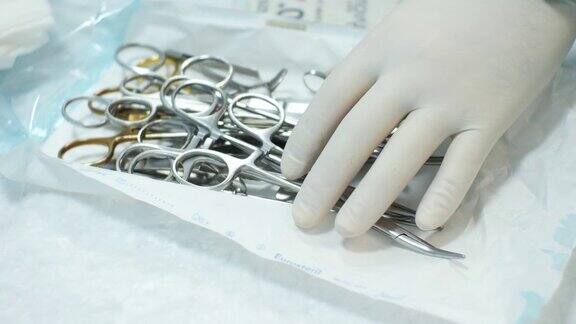 医生为手术打开了一套无菌手术器械医生打开装有消毒器械的包装无菌手术器械概念集