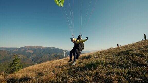 滑翔伞在蓝天中起飞背景是山
