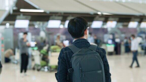 独自旅行的年轻帅哥在出发前正在机场检查他的航班