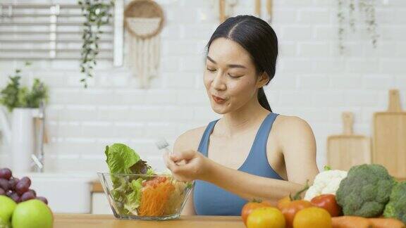 在厨房穿着运动服的活跃运动女孩的肖像她在厨房吃健康的食物保健和饮食