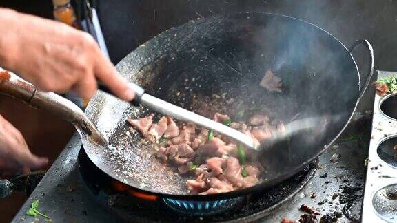 在泰国街头小吃用煎锅煮肉片