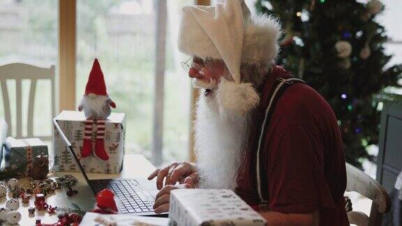 圣诞老人在家里使用笔记本电脑