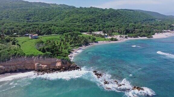 空中向后拍摄普拉亚奎梅托与岩石在海上热带景观和杂草丛生的山为背景-美丽的阳光明媚的一天在海岸线上的巴拉奥纳