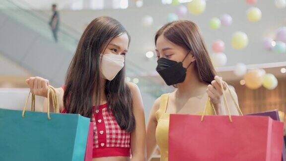 新常态购物亚洲女性在服装店购物戴口罩