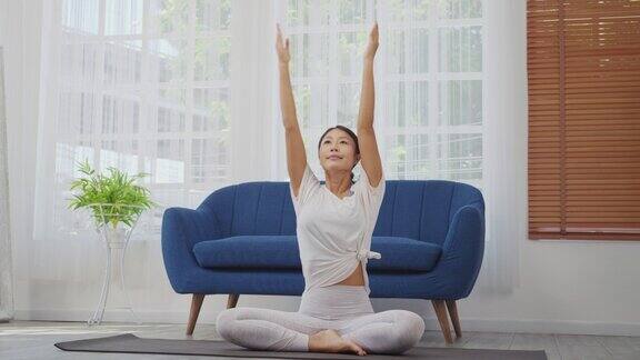 女性在家做伸展运动坐在垫子上的侧角姿势瑜伽锻炼