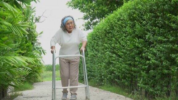 亚洲老年妇女忍受着在自家后院独自散步的痛苦