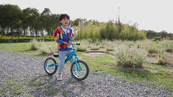 一个小男孩在公园里骑自行车