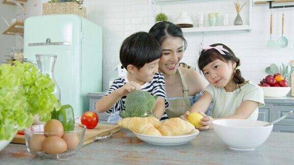 快乐的亚洲家庭在家里的厨房里做饭一起享受家庭活动