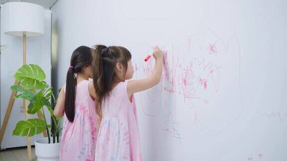 亚洲小女孩喜欢在客厅的白墙上作画可爱的小朋友们在家里愉快地画画、涂色享受着节日的创意活动