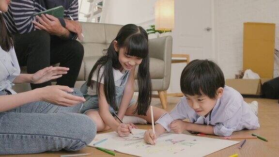 亚洲家庭休闲用彩色铅笔一起在客厅地板上画画