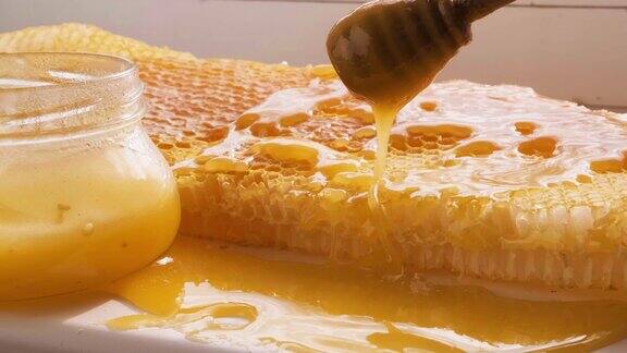 蜂蜜从蜂蜜匙滴到蜂巢架上天然液体蜂蜜从滴管上滴落到蜂蜡上