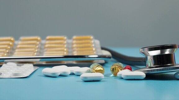 蓝色背景上的药片和听诊器医学概念