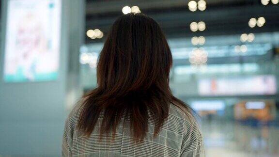 亚洲女商人拿着护照和行李走在国际机场
