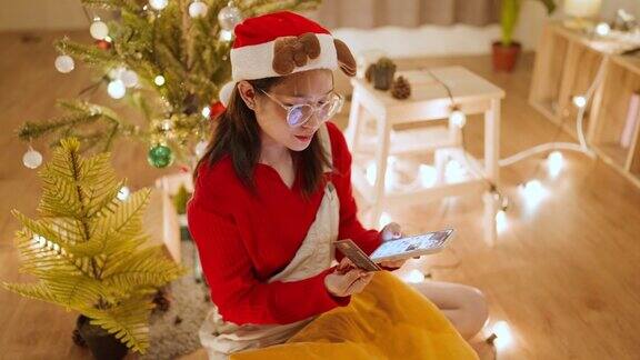 美丽的年轻亚洲女子在圣诞大减价期间网购