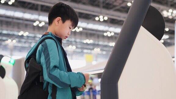 自动化系统是促进各种活动的东西亚洲男孩在机场使用自动登机机制作登机牌暑假期间去旅游从旅行中探索经验和学习