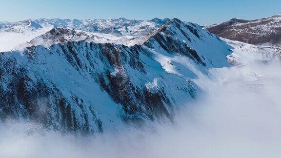 空中雪山景观与雾云漂浮在中国四川嘉晋山的山谷