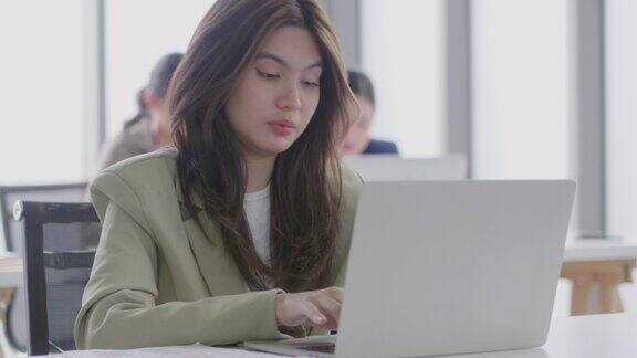 年轻的女商人努力工作厌倦了你正在做的工作一位女士坐在办公室的办公桌前使用笔记本电脑疲劳综合症