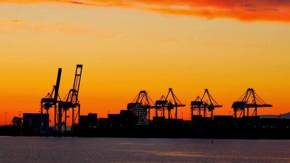 港口起重机货运码头集装箱和船舶的黄昏